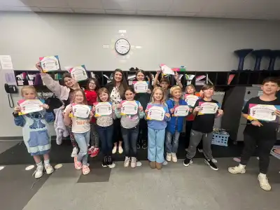 Image of a volunteer with group of students holding certificates